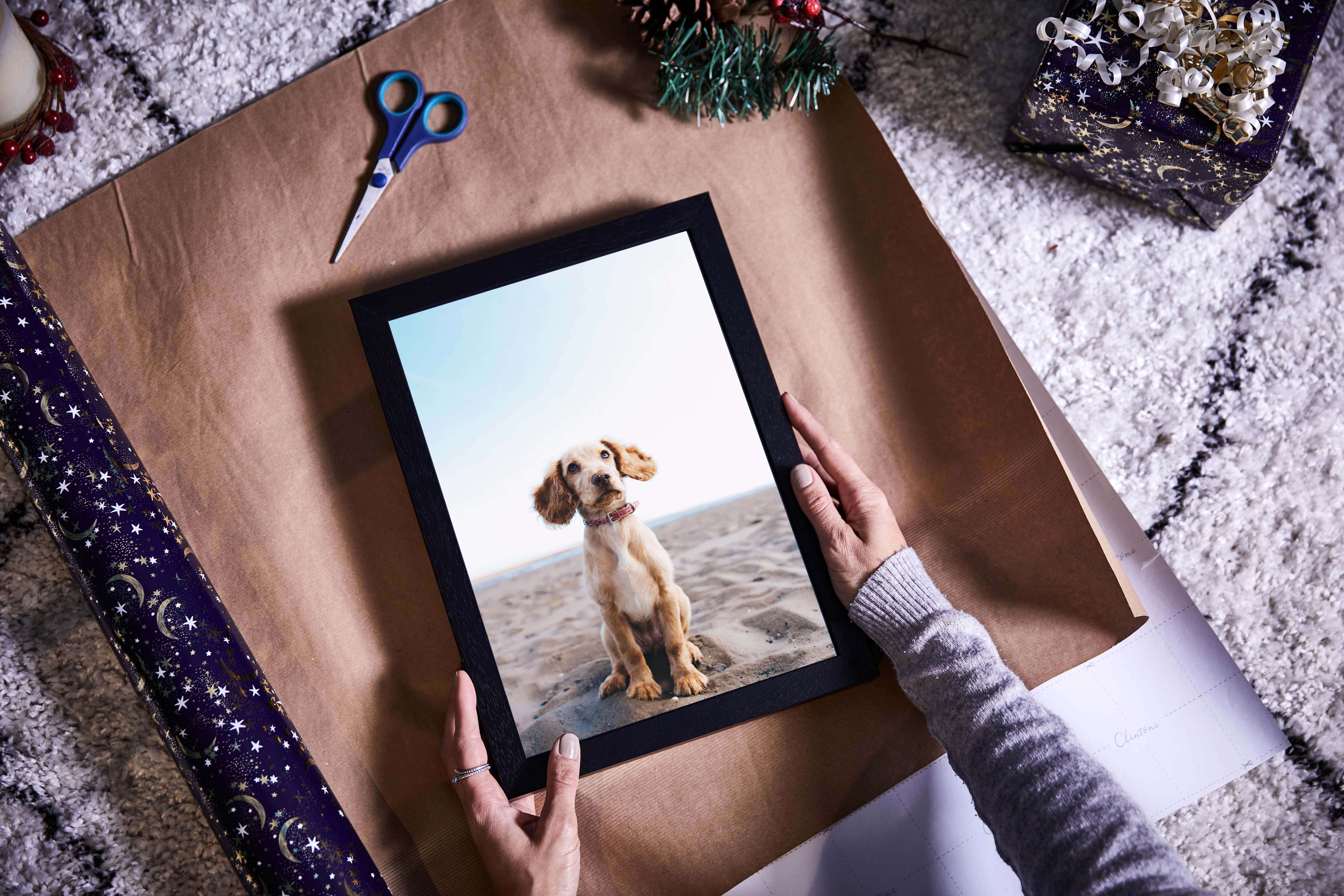 A quality canvas print of a dog on the beach in a made to order black picture frame to give as the perfect personalised christmas gift